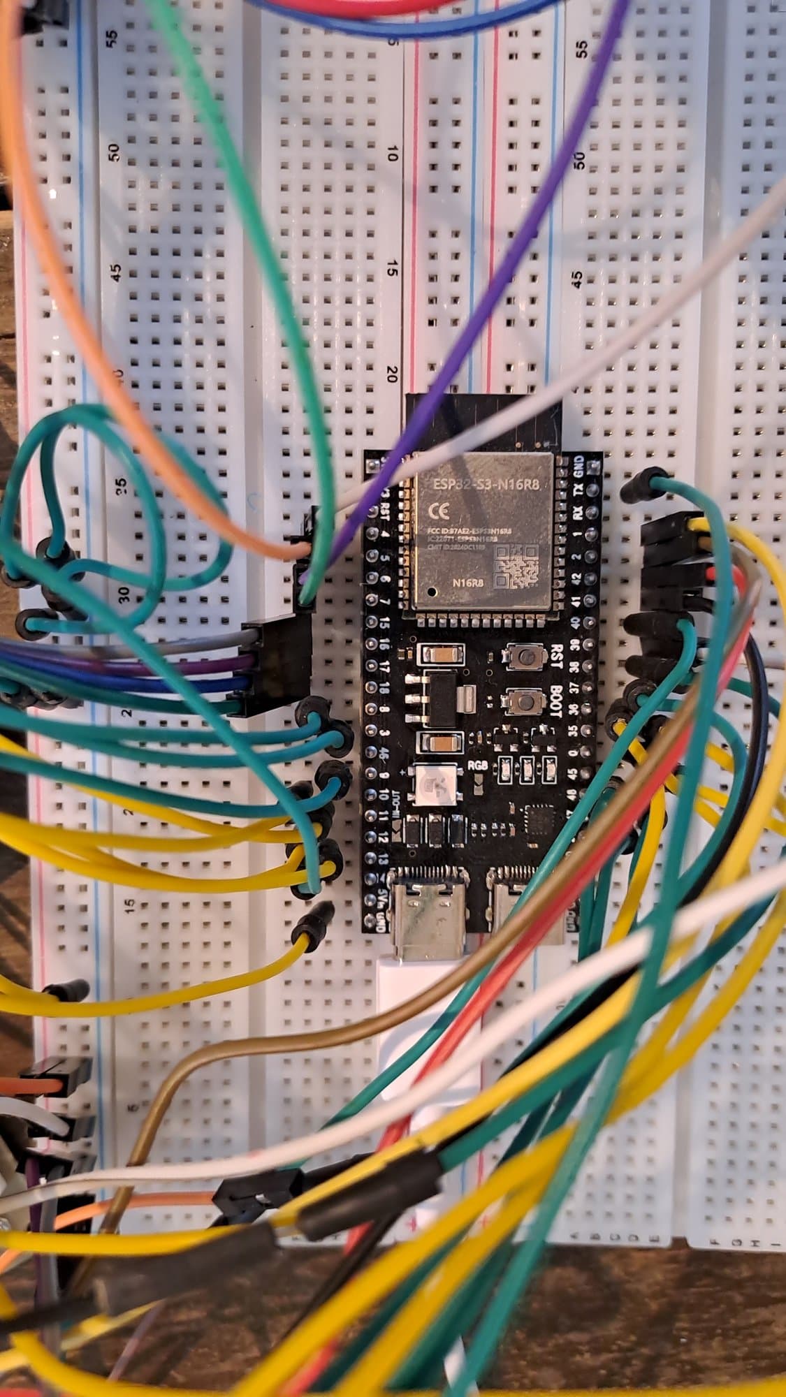 Close-up of the ESP32-S3 board on a breadboard with jumper wires on both sides.